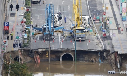 Japan crews work 'around the clock' to fill giant sinkhole