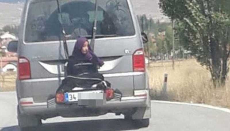 Turkish dad drives along with his daughter tied to minibus