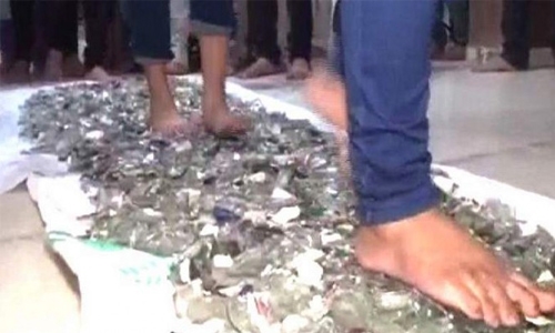 Indian students walk barefoot on broken glass