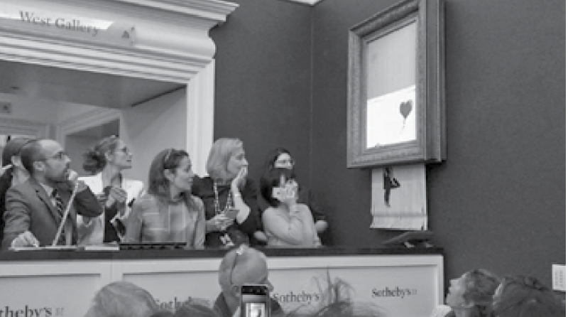 Banksy’s artwork shreds itself after selling for $1.4m