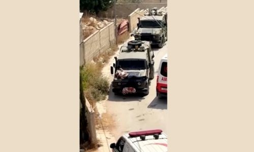 Israeli soldiers tie injured man to jeep during raid