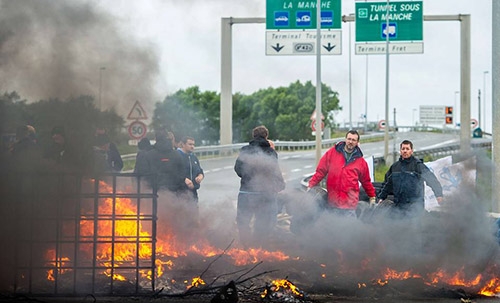 Tensions high as migrants block roads to Calais port